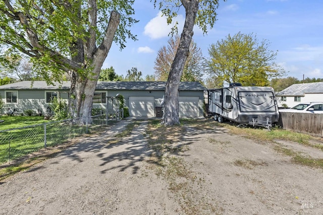 view of front of property featuring a garage, fence, and driveway