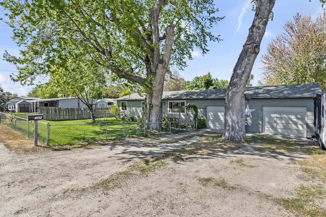 view of front of property featuring fence, a garage, driveway, and a front yard