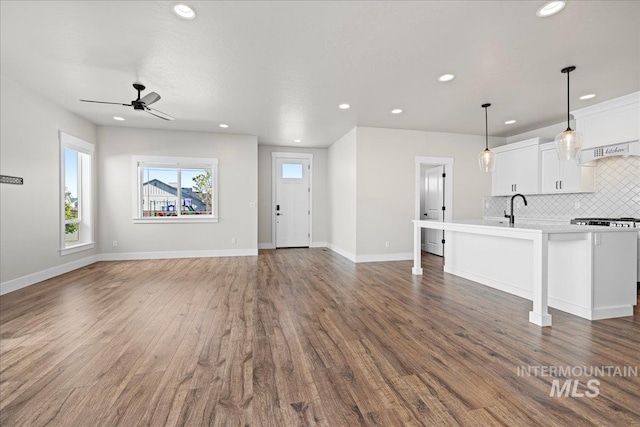 2187 E Hidcote St, Meridian, ID 83642 - unfurnished living room featuring recessed lighting, a ceiling fan, wood finished floors, a sink, and baseboards