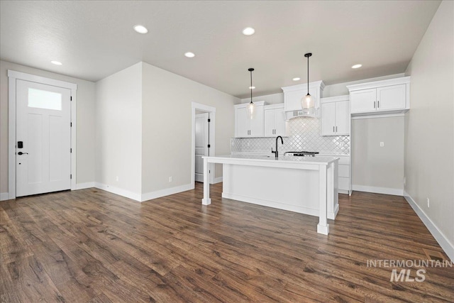 2187 E Hidcote St, Meridian, ID 83642 - kitchen featuring decorative backsplash, dark wood-type flooring, white cabinetry, an island with sink, and recessed lighting