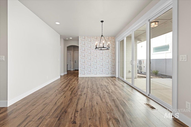 2187 E Hidcote St, Meridian, ID 83642 - unfurnished dining area featuring arched walkways, wood finished floors, a chandelier, baseboards, and recessed lighting