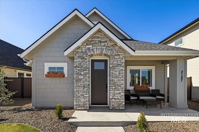 2187 E Hidcote St, Meridian, ID 83642 - property entrance featuring covered porch, stone siding, and roof with shingles