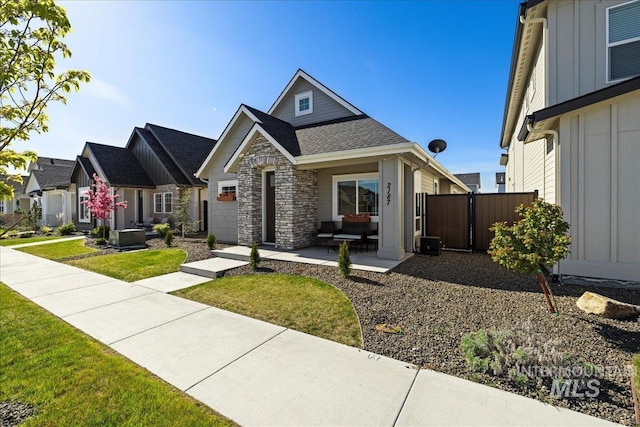 2187 E Hidcote St, Meridian, ID 83642 - view of front of home with board and batten siding, stone siding, roof with shingles, and a patio