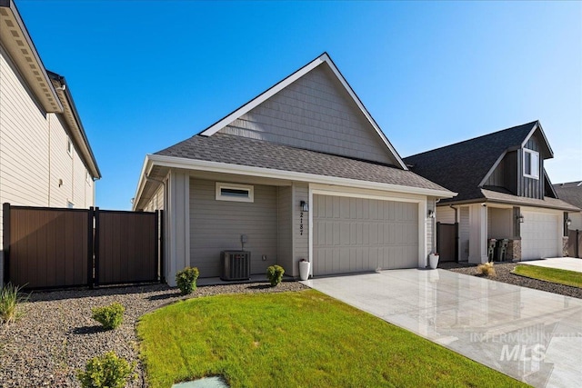 2187 E Hidcote St, Meridian, ID 83642 - view of front of home featuring concrete driveway, a garage, cooling unit, and roof with shingles