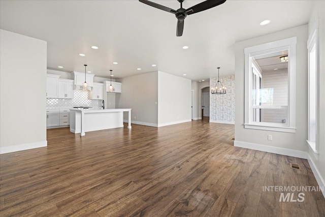 2187 E Hidcote St, Meridian, ID 83642 - unfurnished living room featuring recessed lighting, a ceiling fan, a chandelier, dark wood finished floors, and baseboards