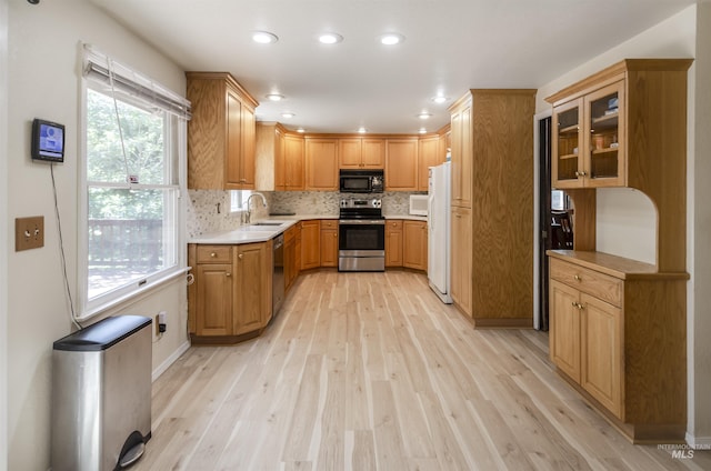 3344 N Tumbleweed, Boise, ID 83713 - kitchen featuring stainless steel appliances, light wood-style flooring, decorative backsplash, light countertops, and glass insert cabinets