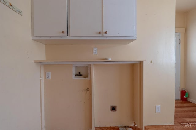 clothes washing area with cabinet space, hookup for an electric dryer, and hookup for a washing machine