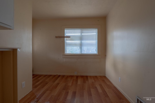 spare room with visible vents, baseboards, and light wood finished floors