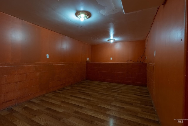 basement with concrete block wall and wood finished floors