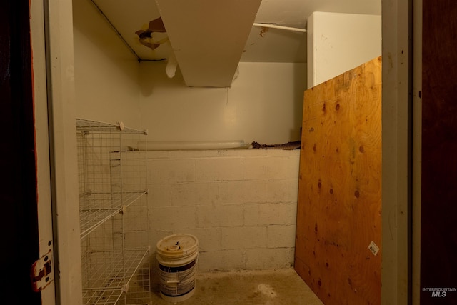 bathroom featuring concrete block wall