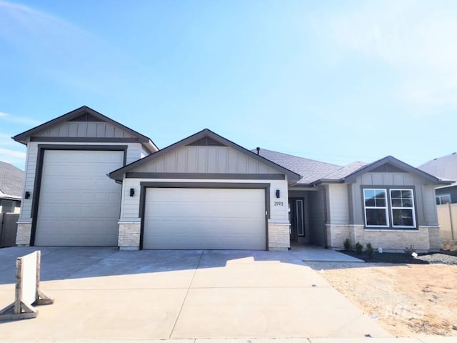 single story home with driveway, board and batten siding, an attached garage, and stone siding
