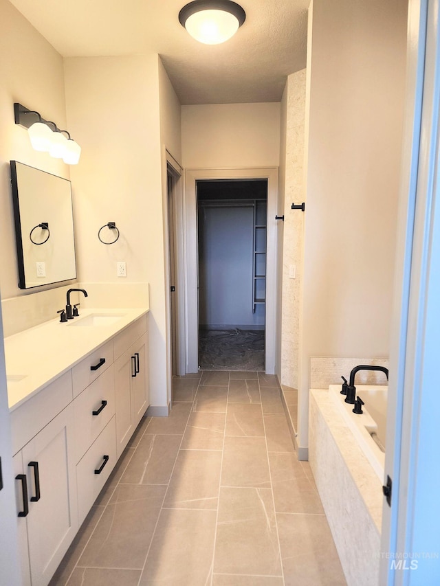 bathroom featuring a garden tub, tile patterned flooring, and vanity