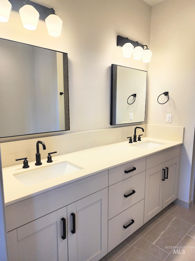 bathroom featuring tile patterned flooring, double vanity, and a sink