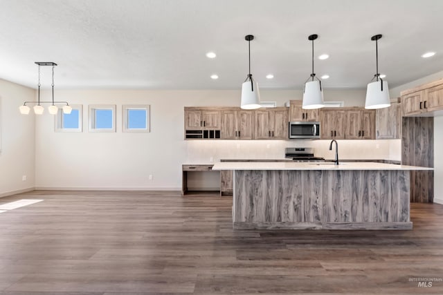 kitchen featuring a sink, appliances with stainless steel finishes, light countertops, baseboards, and recessed lighting