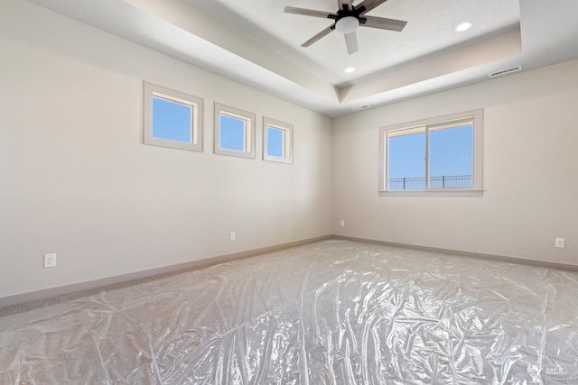 empty room with recessed lighting, ceiling fan, baseboards, visible vents, and a raised ceiling