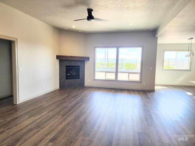 unfurnished living room featuring a textured ceiling, ceiling fan, and a healthy amount of sunlight