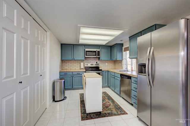 1214 E Pennsylvania Pl, Nampa, ID 83686 - kitchen featuring stainless steel appliances, a sink, blue cabinetry, decorative backsplash, and light tile patterned floors