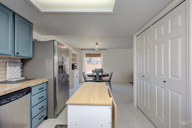 1214 E Pennsylvania Pl, Nampa, ID 83686 - kitchen featuring stainless steel appliances, blue cabinets, wood counters, light tile patterned flooring, and decorative backsplash