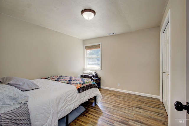 1214 E Pennsylvania Pl, Nampa, ID 83686 - bedroom with wood finished floors, baseboards, a closet, and a textured ceiling