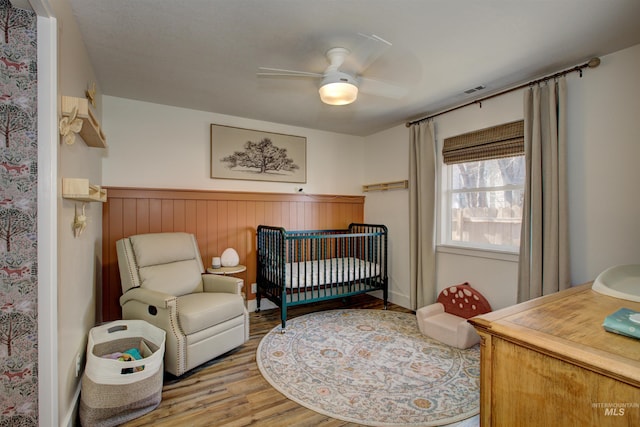 1214 E Pennsylvania Pl, Nampa, ID 83686 - bedroom with wood finished floors, a ceiling fan, and wainscoting