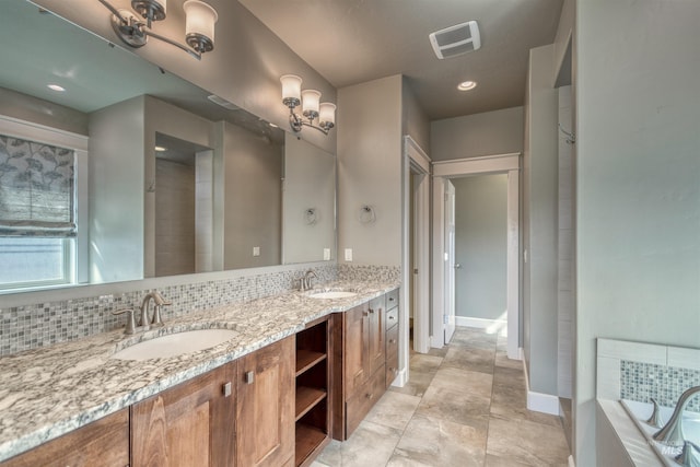 bathroom featuring baseboards, a sink, visible vents, and double vanity