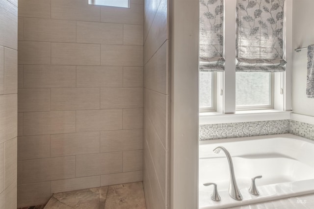 bathroom featuring a bath and a wealth of natural light