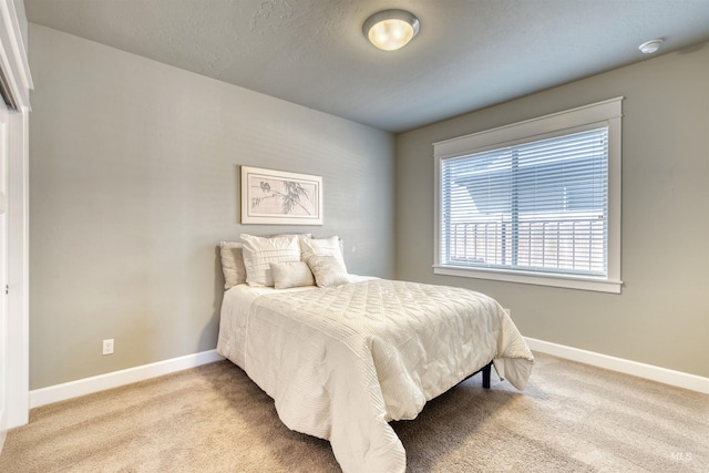bedroom featuring baseboards and light colored carpet