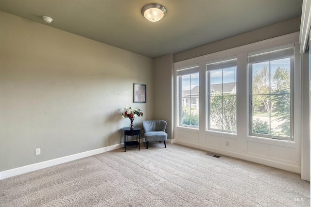 living area featuring carpet, visible vents, and baseboards