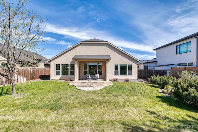 back of property with a patio area, a lawn, and a fenced backyard