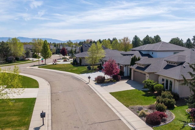 view of street with a residential view, curbs, sidewalks, and a mountain view