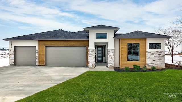 prairie-style home with a garage and a front lawn