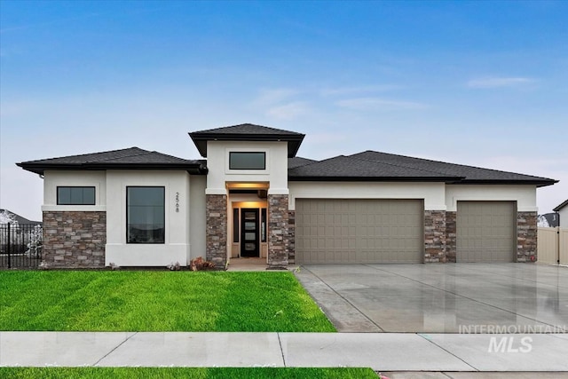 prairie-style home featuring a garage and a front yard