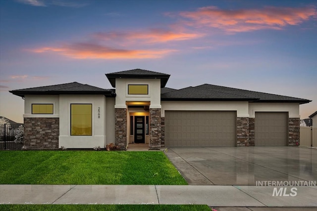 prairie-style home with a garage and a yard