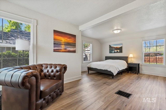 2706 W Ponderosa Rd, Boise, ID 83705 - bedroom with visible vents, wood finished floors, baseboards, vaulted ceiling with beams, and a textured ceiling