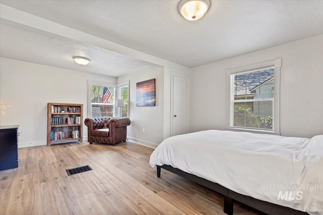 2706 W Ponderosa Rd, Boise, ID 83705 - bedroom with a textured ceiling, baseboards, visible vents, and light wood-style flooring