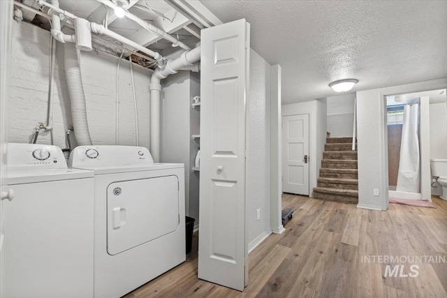 2706 W Ponderosa Rd, Boise, ID 83705 - laundry room featuring light wood-style floors, washing machine and dryer, and a textured ceiling
