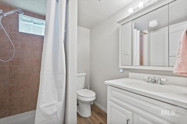 2706 W Ponderosa Rd, Boise, ID 83705 - full bath featuring a textured wall, vanity, toilet, shower / bath combo with shower curtain, and wood finished floors