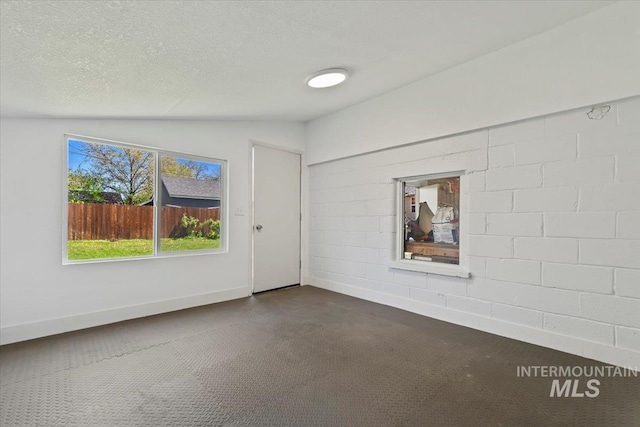 2706 W Ponderosa Rd, Boise, ID 83705 - empty room with baseboards, vaulted ceiling, dark carpet, and a textured ceiling