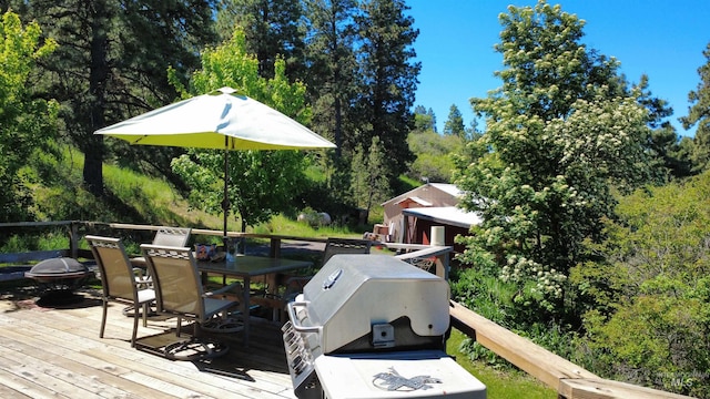 39055 Hilltop Ln, Lewiston, ID 83501 - wooden deck featuring outdoor dining area, a fire pit, and area for grilling