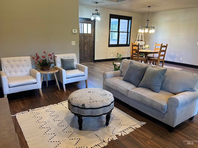 living room with a notable chandelier and dark hardwood / wood-style flooring