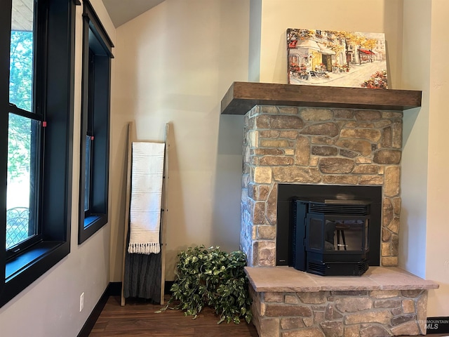 interior details featuring hardwood / wood-style flooring, a wood stove, and a fireplace