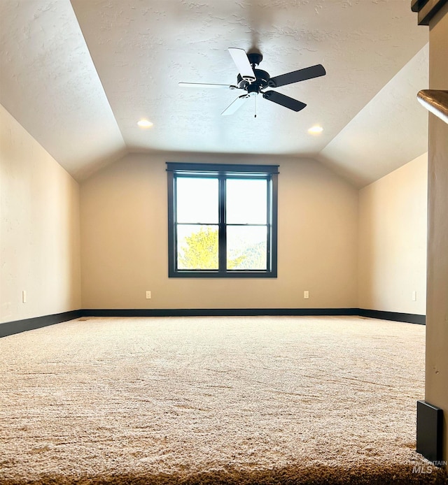 additional living space with ceiling fan, vaulted ceiling, a textured ceiling, and carpet flooring