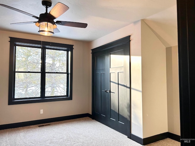 carpeted entryway with ceiling fan