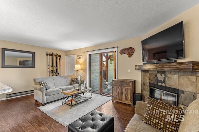 601 Hemlock St Unit 3, Mccall, ID 83638 - living room featuring a baseboard heating unit, hardwood / wood-style floors, a tiled fireplace, and a textured ceiling