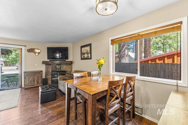 601 Hemlock St Unit 3, Mccall, ID 83638 - dining area featuring dark wood-style floors, a stone fireplace, and a textured ceiling