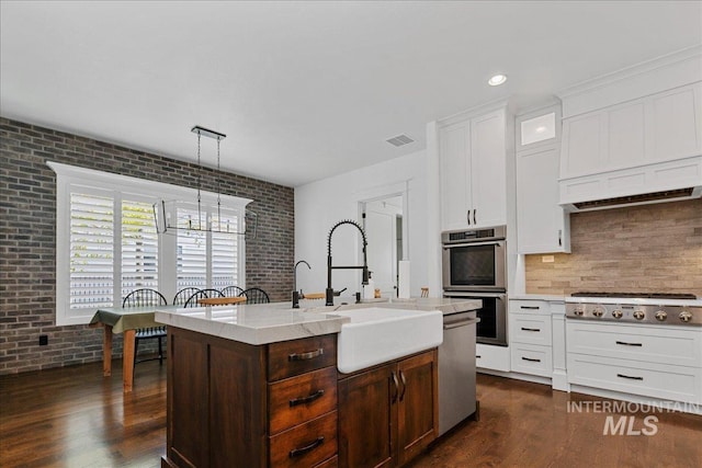 3345 W Dublin St, Eagle, ID 83616 - kitchen with stainless steel appliances, a sink, dark wood-style flooring, a chandelier, and backsplash