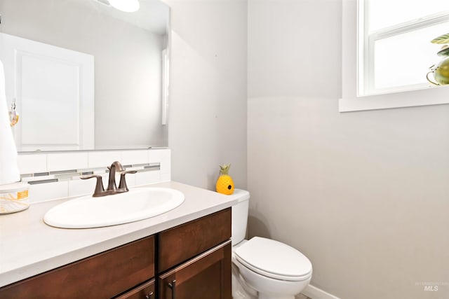 bathroom with toilet, tasteful backsplash, and vanity