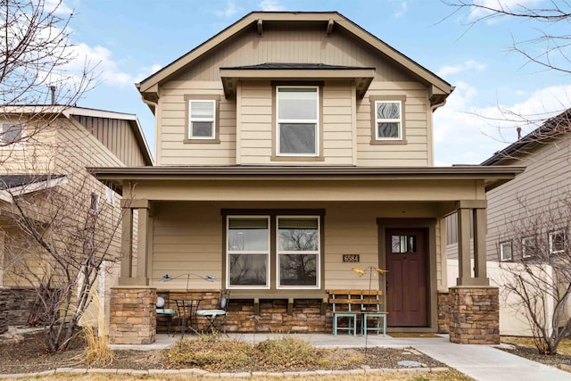 view of front of home with stone siding and covered porch