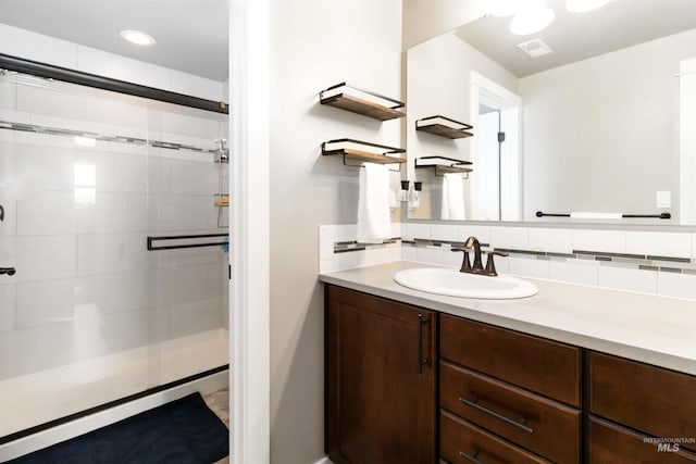 bathroom with visible vents, tasteful backsplash, a stall shower, and vanity