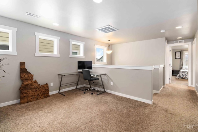 office area with light colored carpet, visible vents, and baseboards